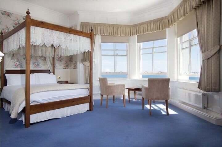 A room with a bay window overlooking the sea at the Queens Hotel